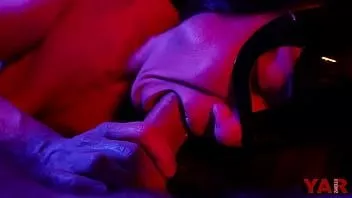 Oynat Maskeli bir kadın, ağzında müzik eşliğinde neon ışıkta hafif bir oral seks ile biten büyük bir horoz emiyor